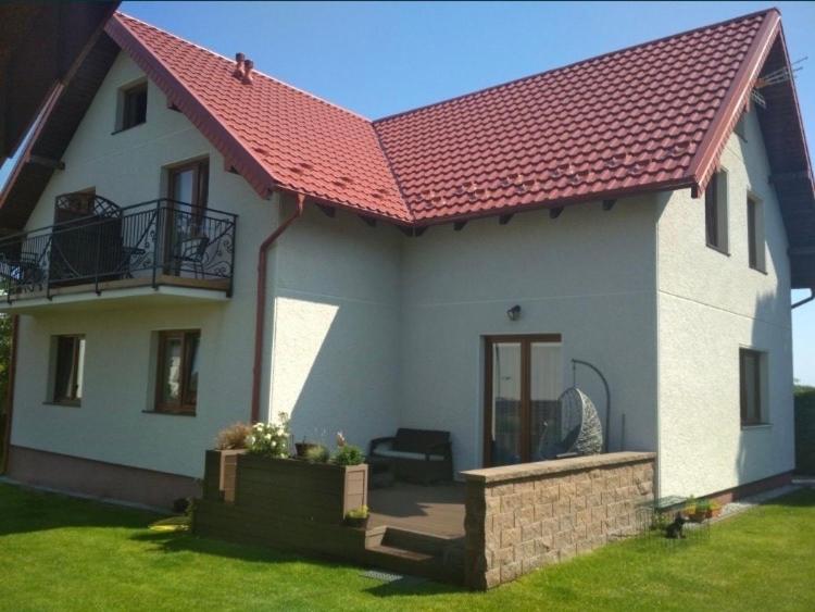 a large white house with a red roof at AsPa in Ostrowo