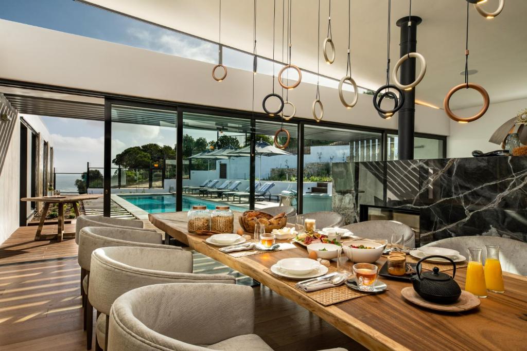 - une salle à manger avec une table, des chaises et une piscine dans l'établissement Vyn Guest House Hout Bay, à Hout Bay