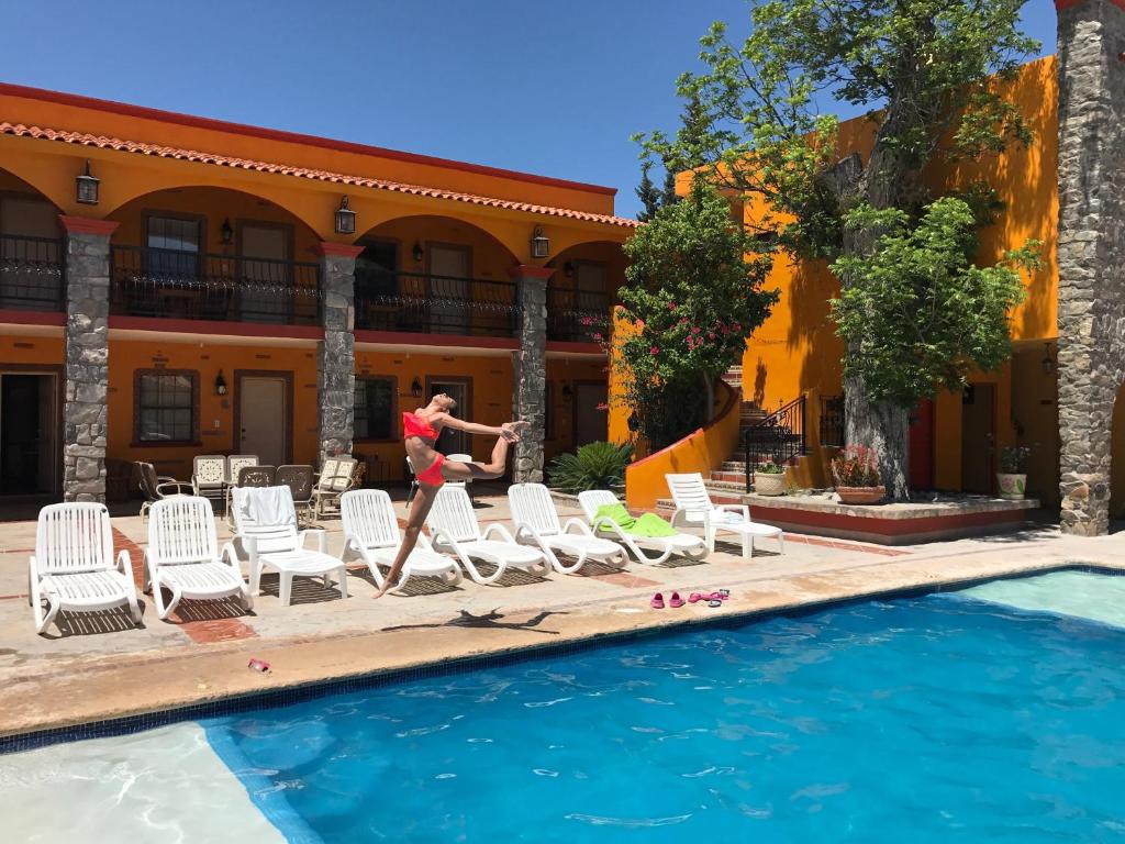 a woman jumping into a swimming pool at a hotel at HOTEL QUINTA SANTA CECILIA in Cuatrociénegas de Carranza