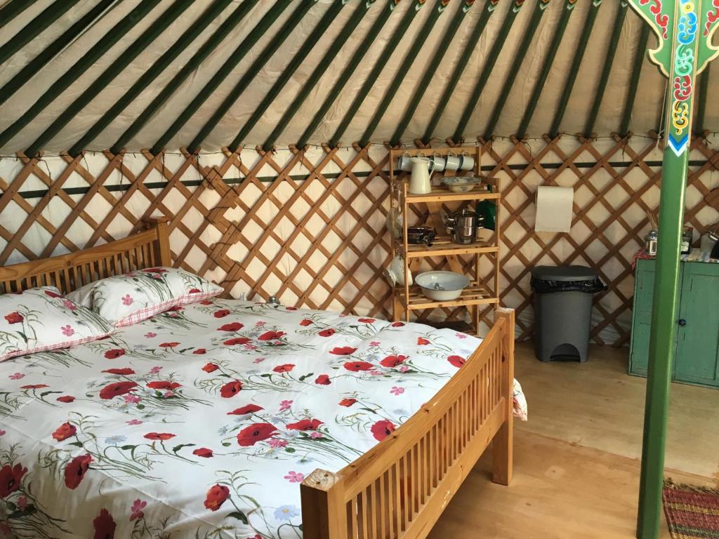 a bedroom with a bed in a yurt at Higher Trenear Farm Yurts in Helston