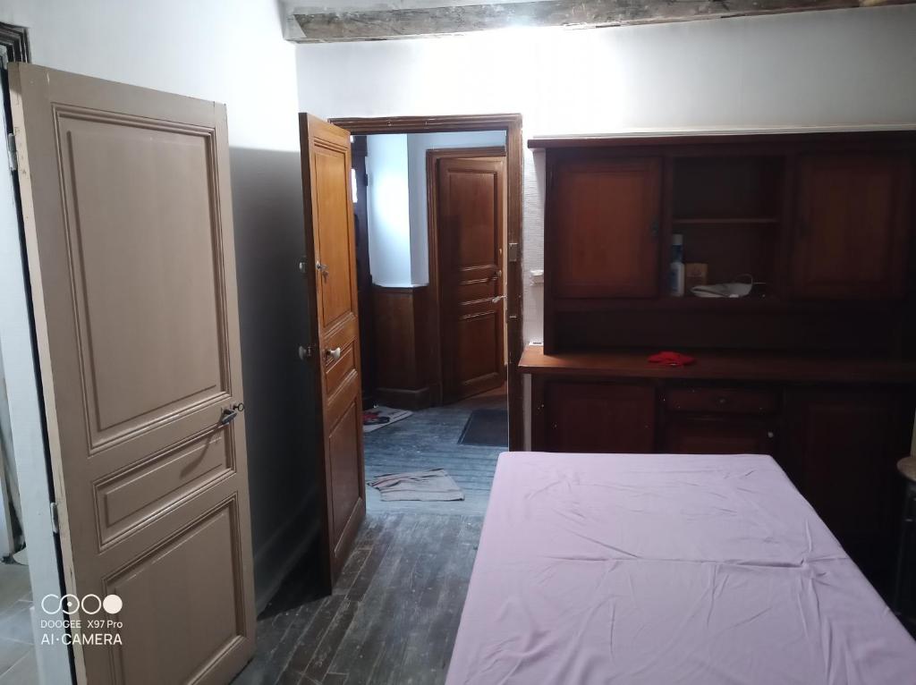 1 dormitorio con cama, armario y puerta en Chambre à petit budget pour personne simple, en Saint-Laurent-de-Neste