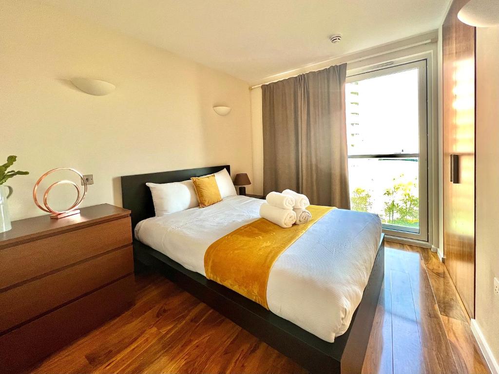 a bedroom with a large bed with a large window at Canary Wharf, E14 9PW, 2 Bedroom Apartment in London