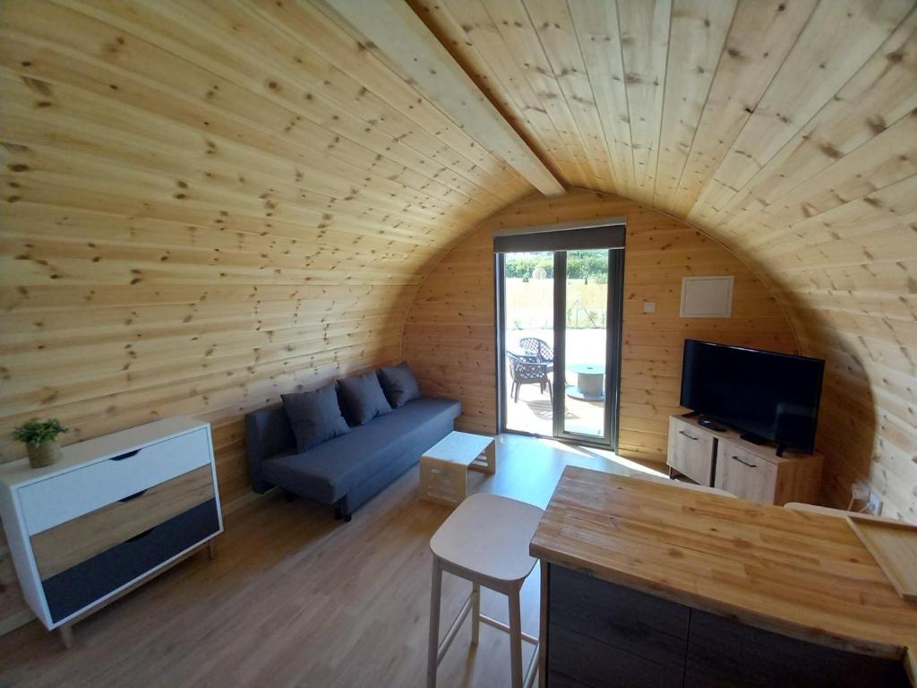 a living room with a blue couch in a wooden room at Glamping Pod in Prodhromi