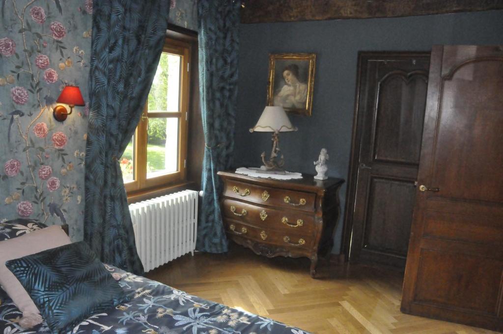 ein Schlafzimmer mit einem Bett, einer Kommode und einem Fenster in der Unterkunft Château de St sauveur d'Emalleville in Émalleville