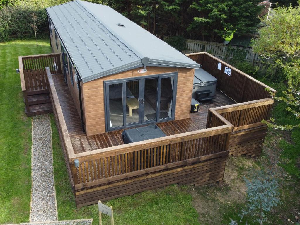 a large wooden cabin with a large deck at Tulip Lodge in Saltburn-by-the-Sea