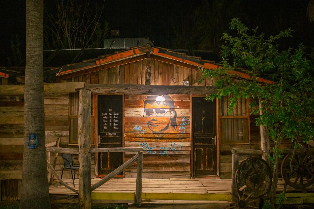 a log cabin with graffiti on it at night at Kadir's Family House in Olympos