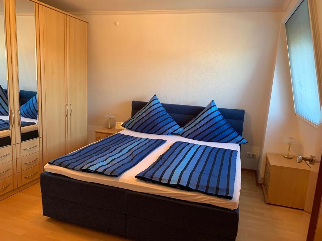 a bedroom with a blue bed with blue pillows at Ferienwohnung zum weißen Schwan in Lübeck