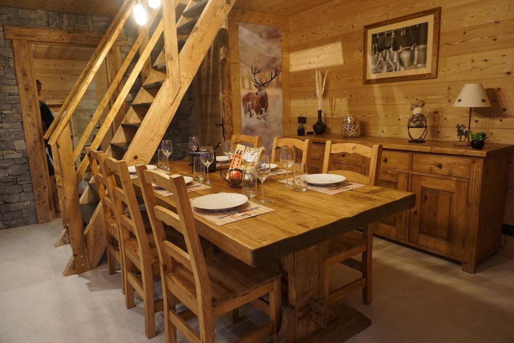 a dining room with a wooden table and chairs at Le chamois, chez le charpentier d'antan, au calme, spacieux T3 duplex, ambiance chalet, vue dégagée, parking privé in Épagny