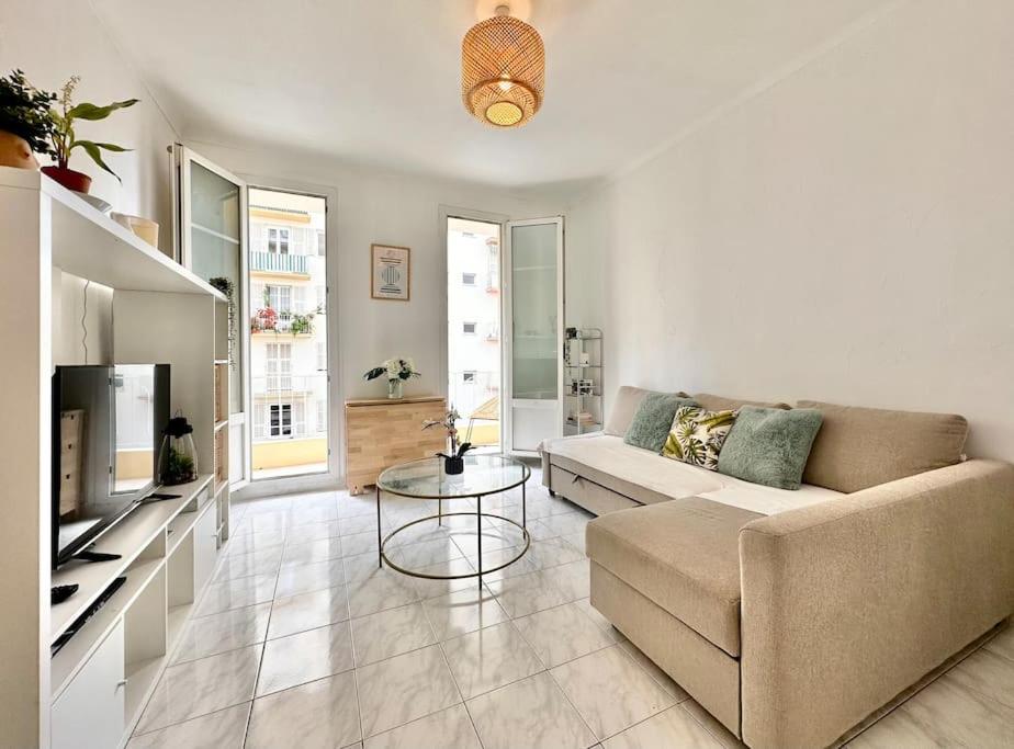 un salon avec un canapé et une table dans l'établissement Cosy apartment - 15 min from beach - Free Parking, à Nice