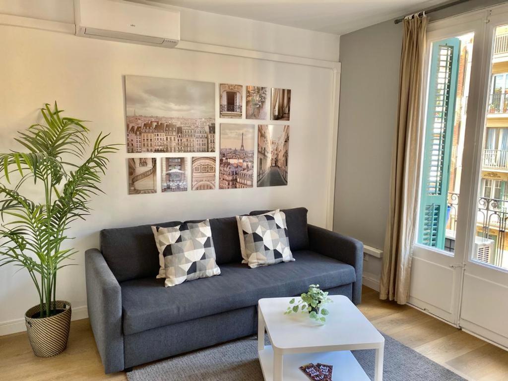 a living room with a blue couch and a table at 2 BDR EIXAMPLE APARTMENT in Barcelona