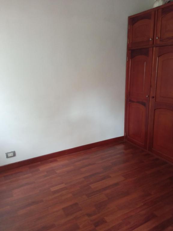 um quarto com uma parede branca e um armário de madeira em Apartamento Duplex em Medellín