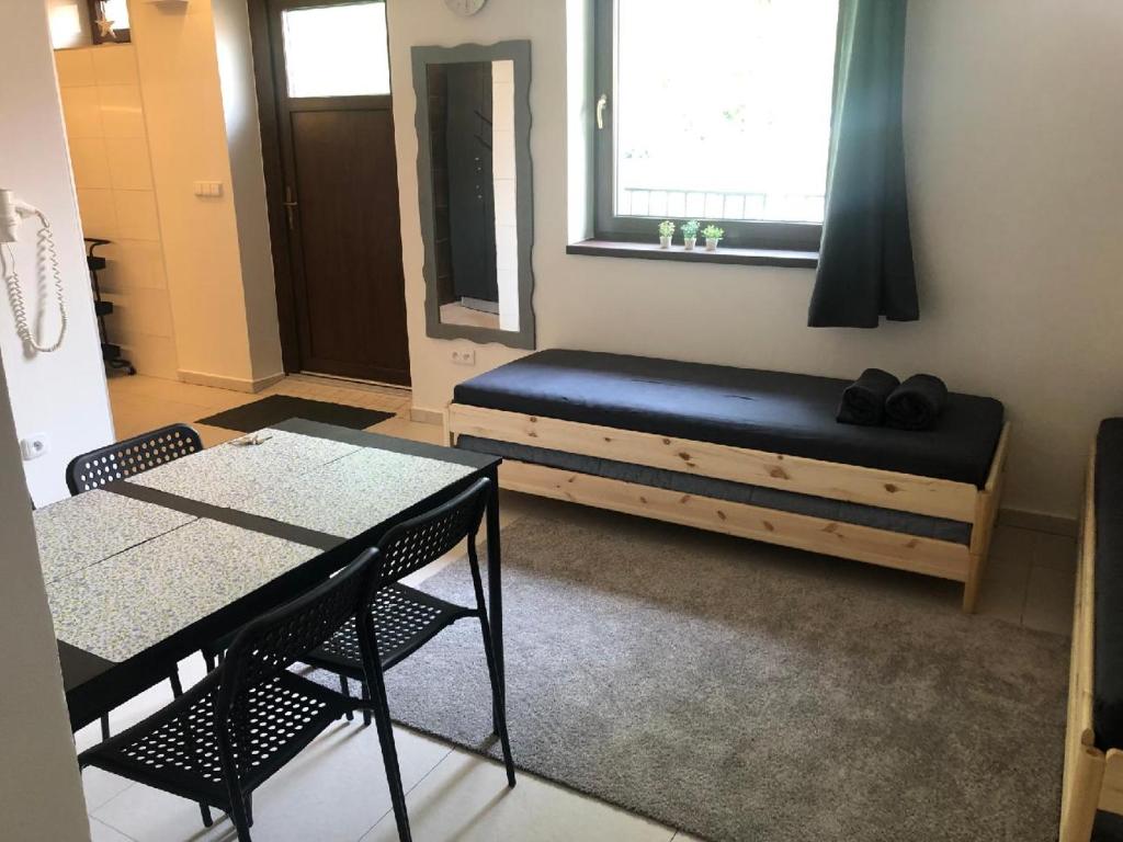 Zimmer mit einem Bett, 2 Tischen und einem Fenster in der Unterkunft Apartmán Wellness Veselí in Veselí nad Moravou