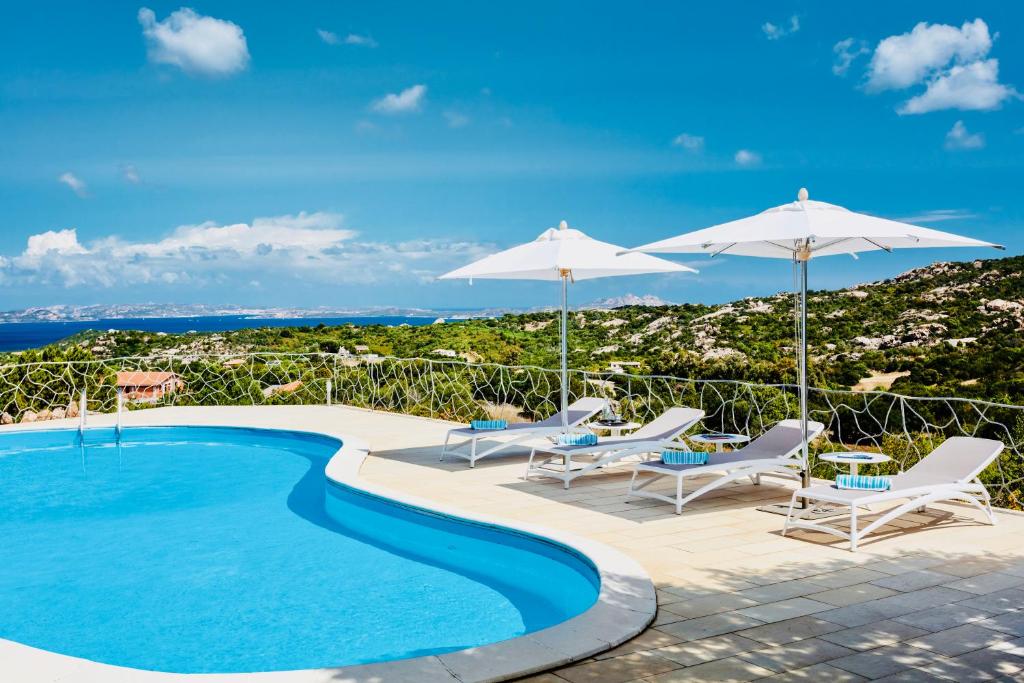 une piscine avec chaises et parasols dans l'établissement Smeralda Oasis, à Arzachena