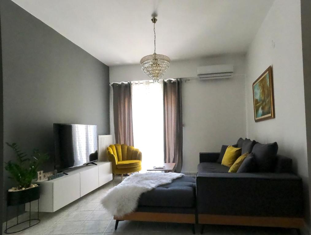 a living room with a couch and a tv at KND Living Concept - Apartment in Heraklio Town