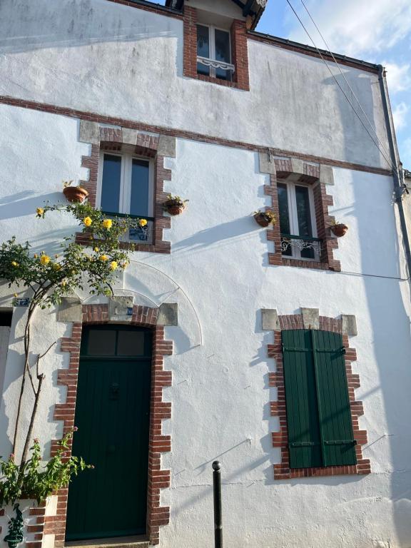 - un bâtiment blanc avec des portes et des fenêtres vertes dans l'établissement Maison de Ville, Hyper Centre, 8p, 105m2, à Pornic