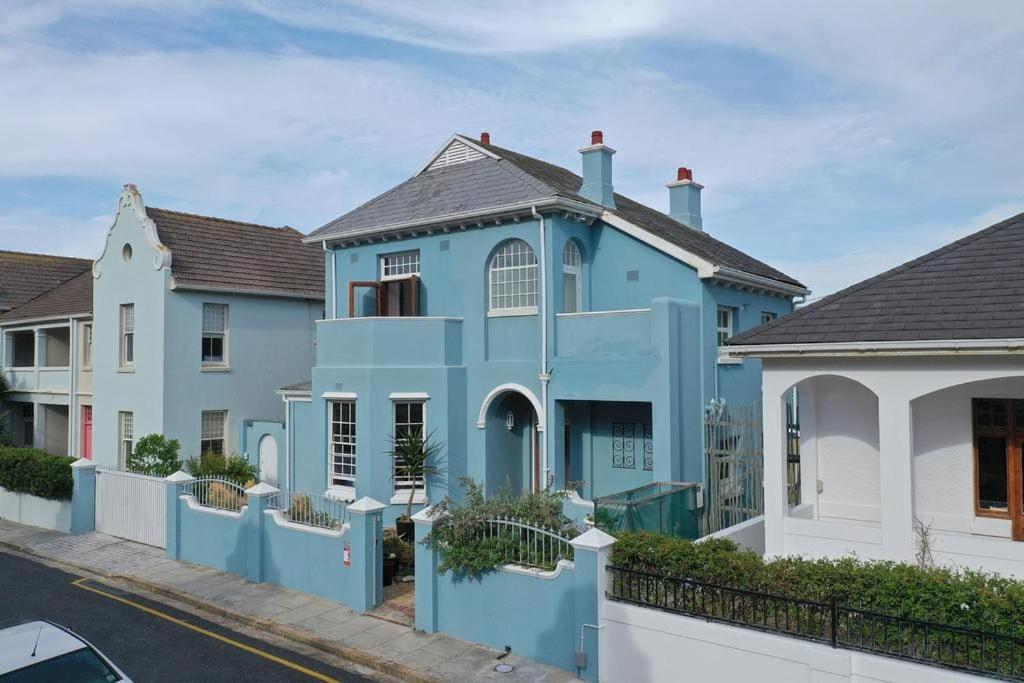 a blue house with a white fence at 'Imagine' - Surfers Corner Muizenberg Village in Cape Town