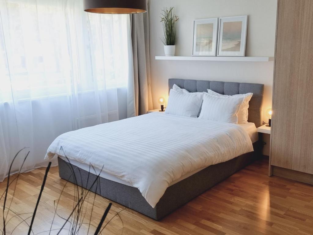 Schlafzimmer mit einem Bett mit weißer Bettwäsche und einem Fenster in der Unterkunft A romantic seaside retreat for two in Meremõisa