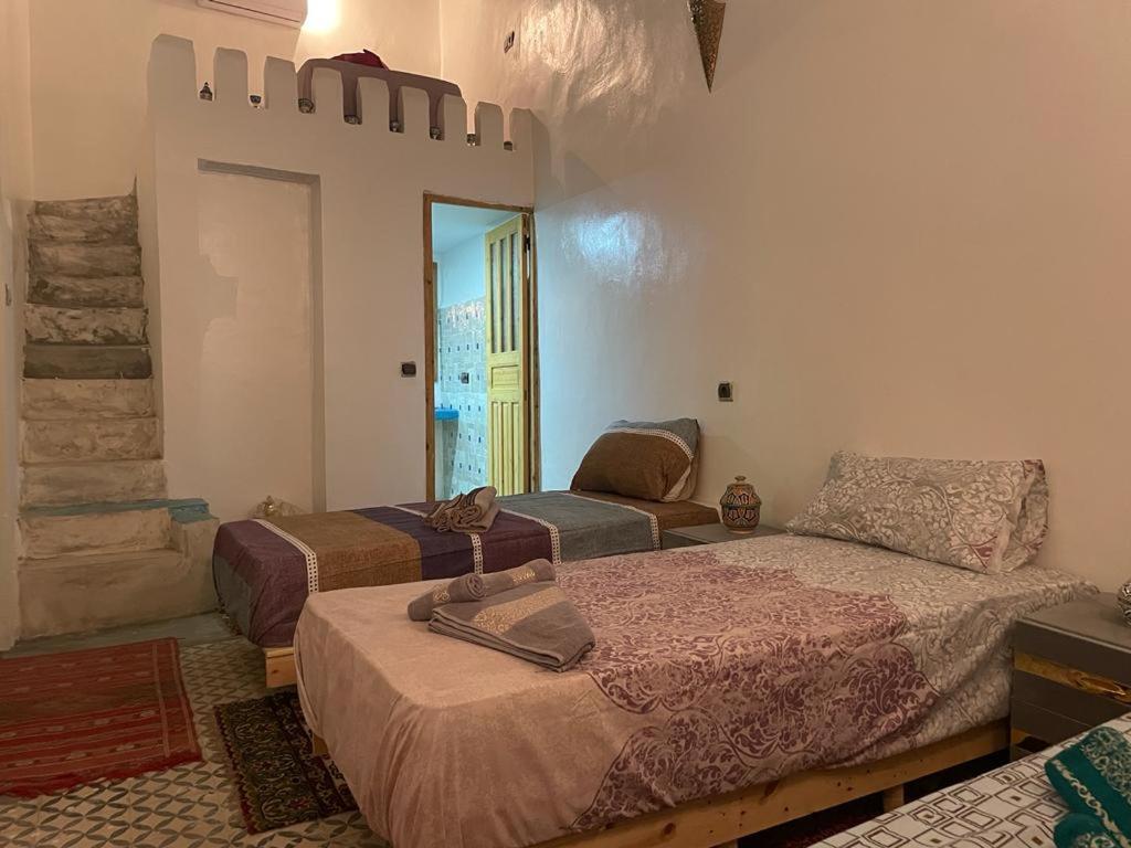 a bedroom with two beds and a mirror at Riad Ali Baba Fes in Fez
