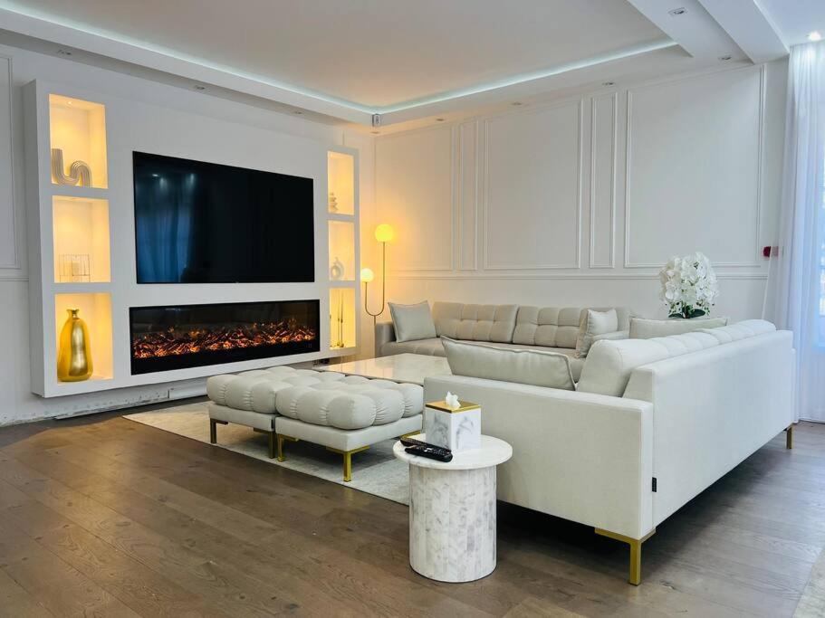 a living room with a white couch and a fireplace at Superbe maison avec jardin in Ris-Orangis