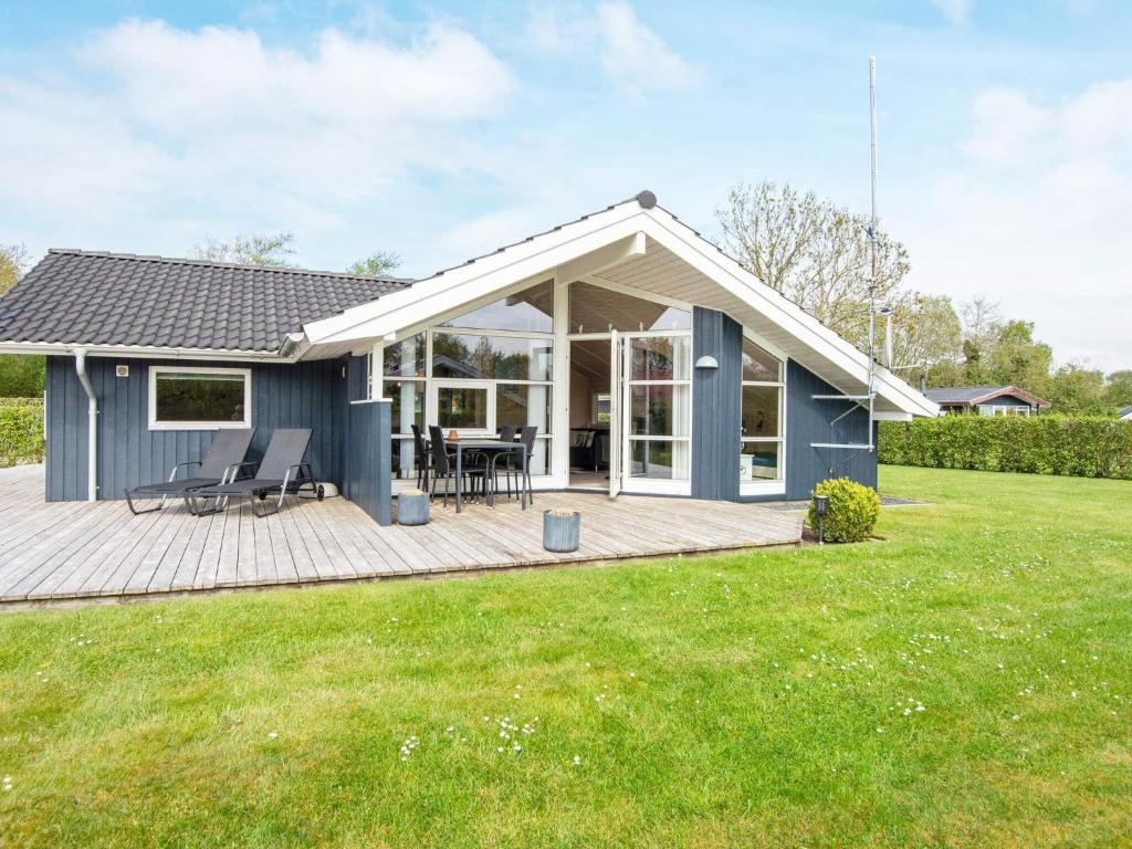 a blue house with a deck in a yard at 6 person holiday home in Hemmet in Falen
