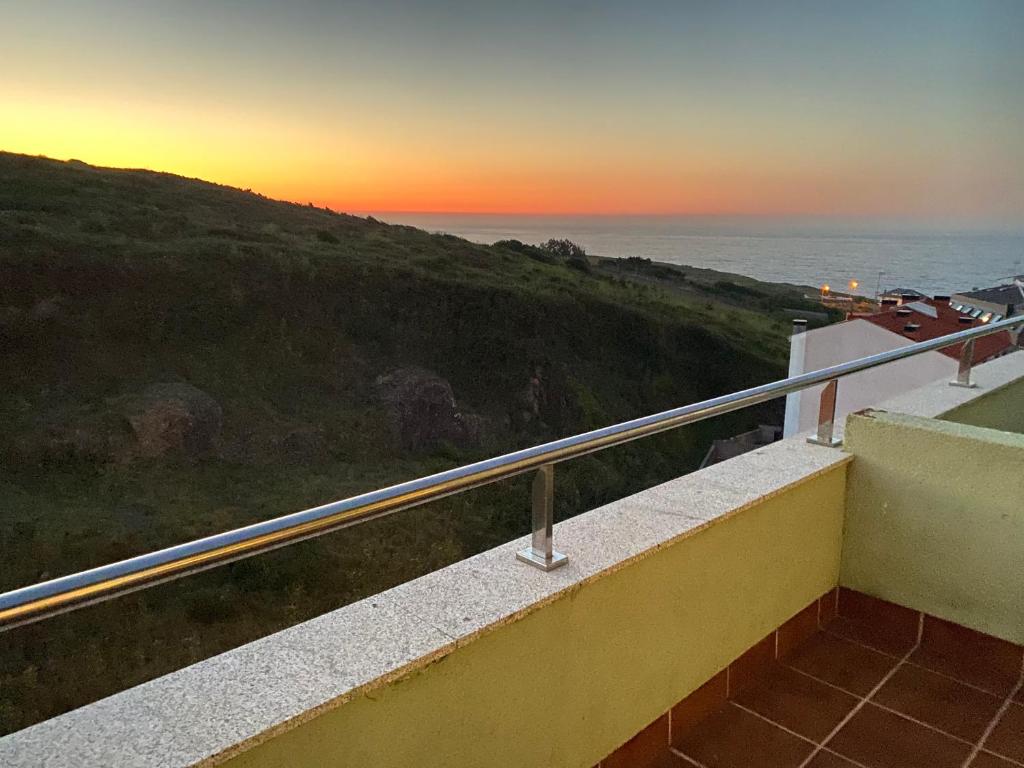 balkon z widokiem na ocean o zachodzie słońca w obiekcie Ático Sisargas, Malpica. w mieście Malpica