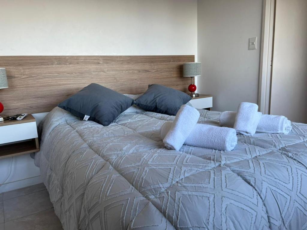 1 dormitorio con 1 cama grande con almohadas azules en plaza serrano corazon en Buenos Aires
