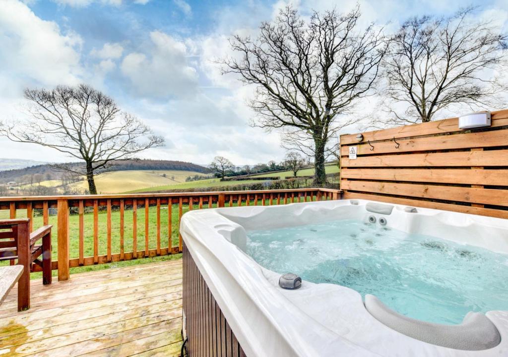 a hot tub on the deck of a house at Hen Ysgubor in Lampeter