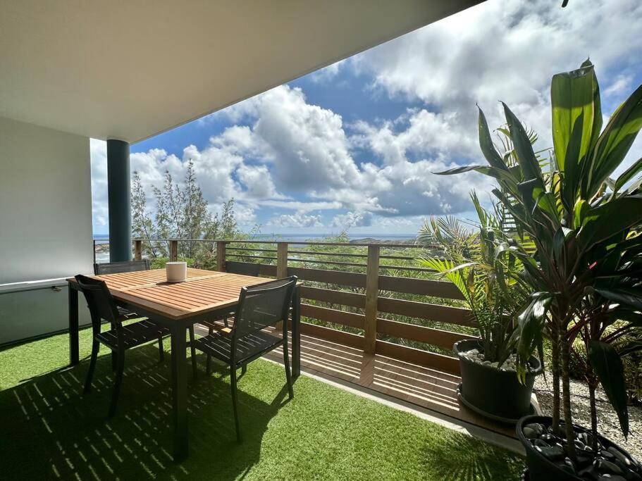 a table and chairs on a balcony with a view of the ocean at View apartment - St Barts in Marigot