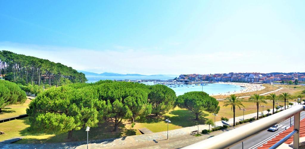 vistas a una playa con árboles y una carretera en Ático de playa con vistas en Baltar - Sanxenxo en Portonovo