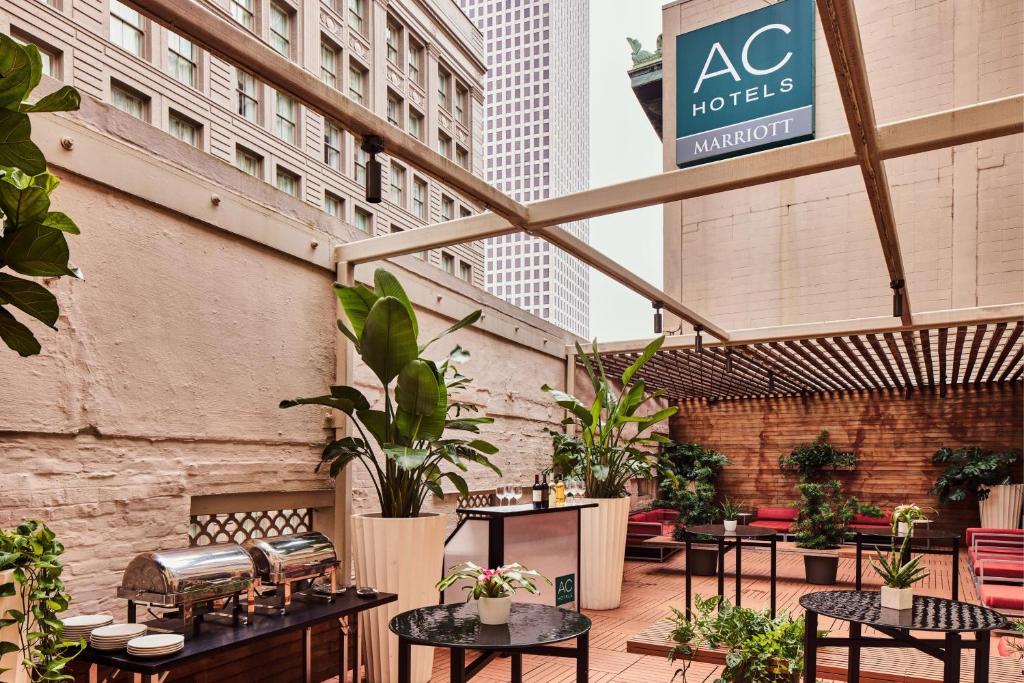 a patio with tables and potted plants and buildings at AC Hotel by Marriott New Orleans French Quarter in New Orleans