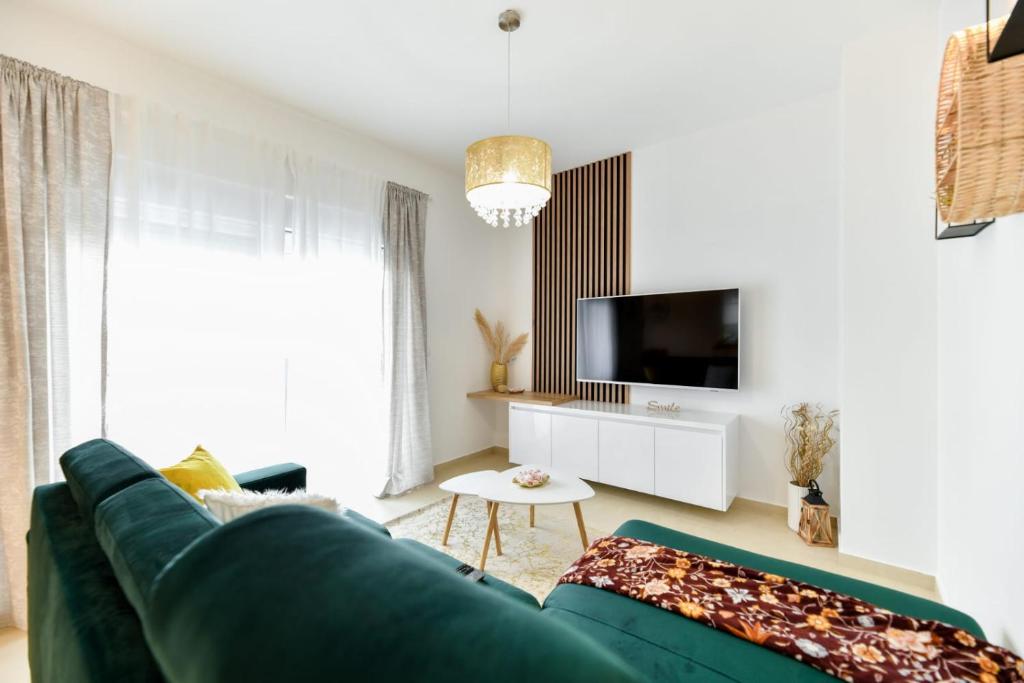 ein Wohnzimmer mit einem grünen Sofa und einem TV in der Unterkunft Family apartment Amare in Zadar