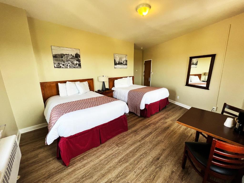 a hotel room with two beds and a desk at Lenox Hotel and Suites in Buffalo