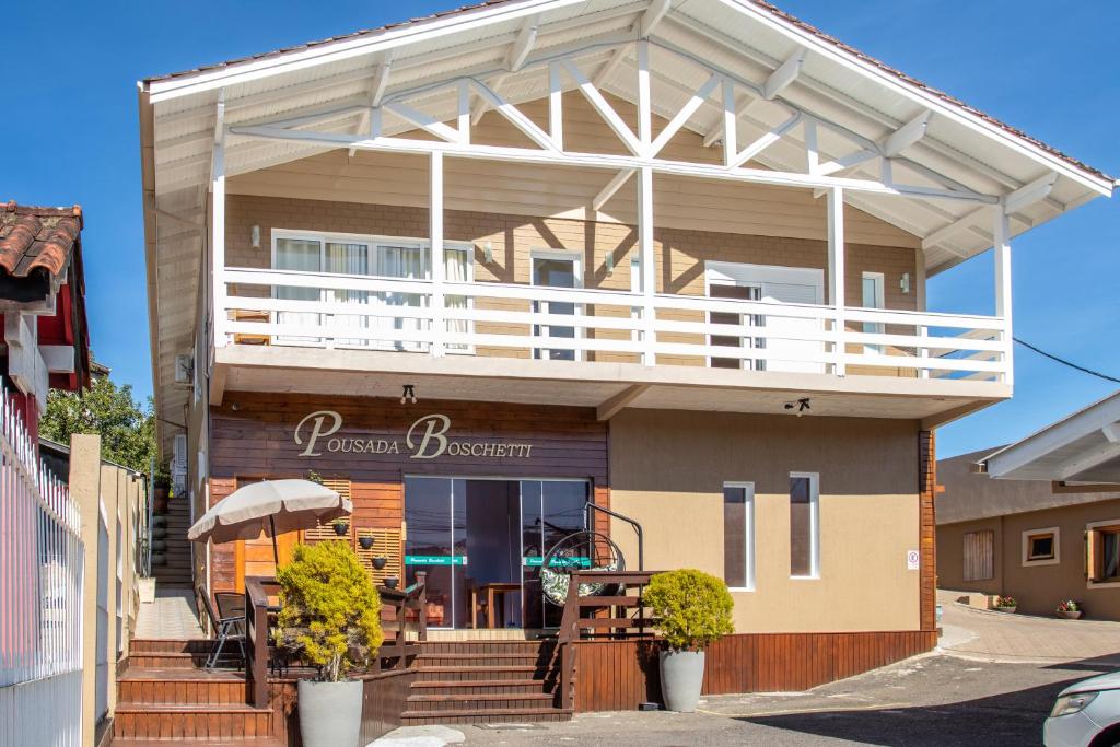 a house with a balcony on top of it at Pousada Boschetti in Gramado