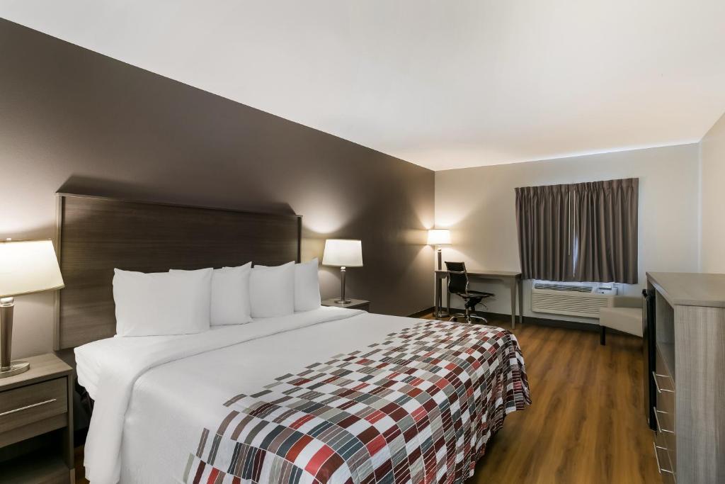 una camera d'albergo con un grande letto e una TV di Red Roof Inn Denver a Denver