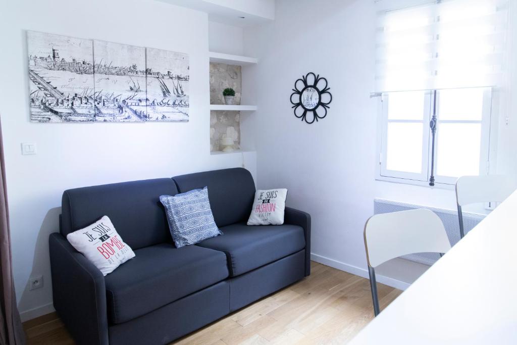un salon avec un canapé bleu et une table dans l'établissement Studios - Centre ville coeur historique, à Arles