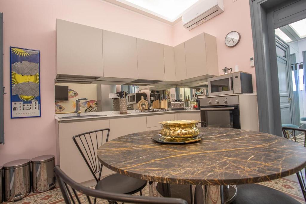 a kitchen with a table and chairs and a kitchen with white cabinets at I Bastioni Apartment in Palermo