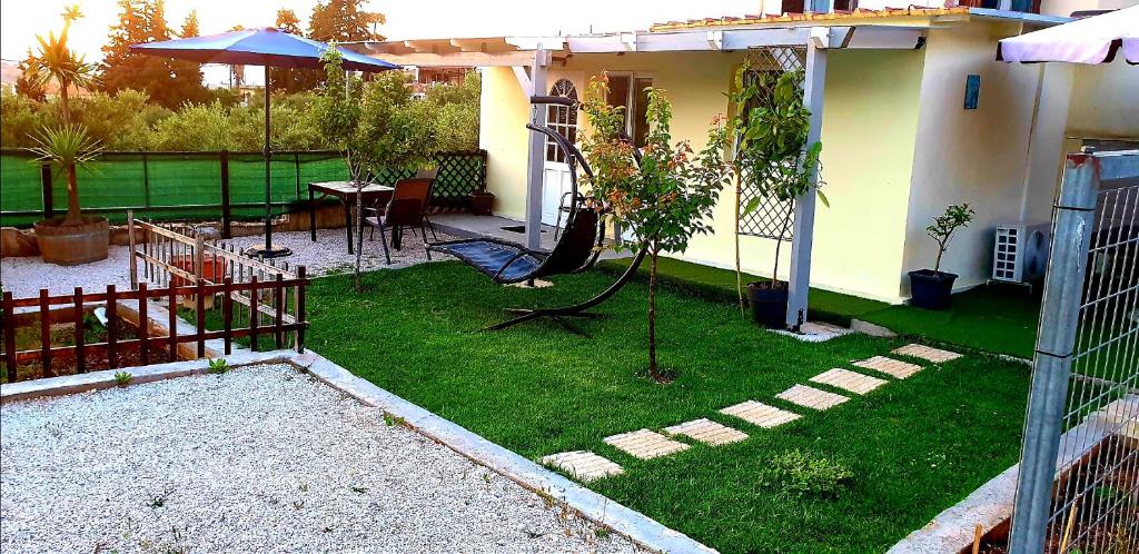 un pequeño patio trasero con un jardín con un columpio en γαληνη, en Vamos