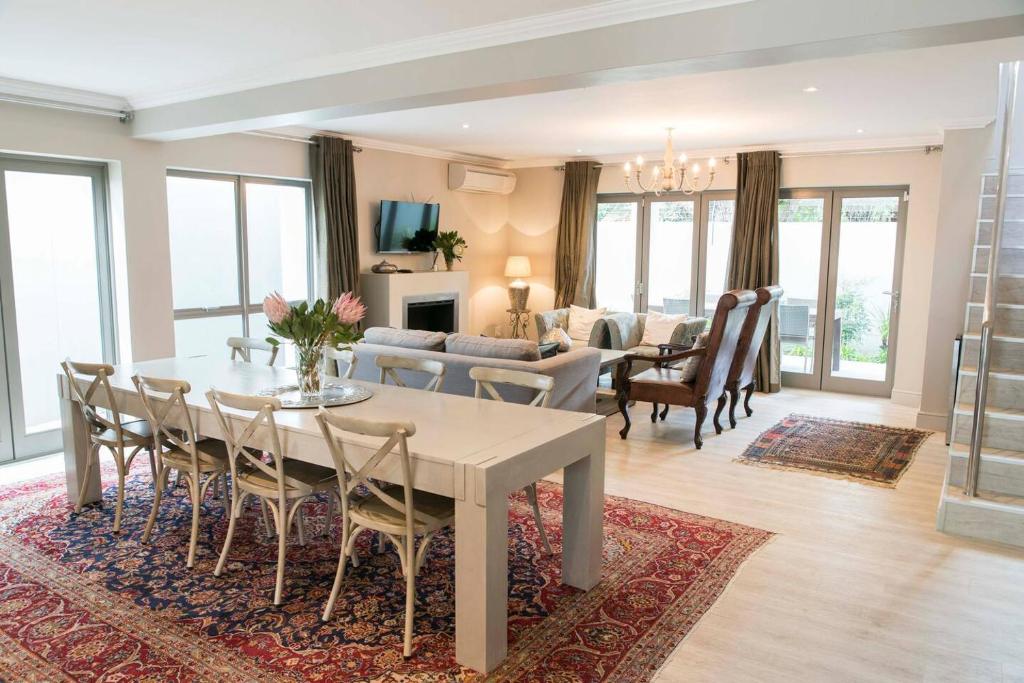 comedor y sala de estar con mesa y sillas en 13 La Gratitude Luxury Apartment-with backup power for loadshedding, en Stellenbosch