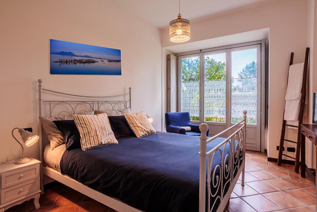 um quarto com uma cama, uma cadeira e uma janela em La Suite del Castello em Belgirate