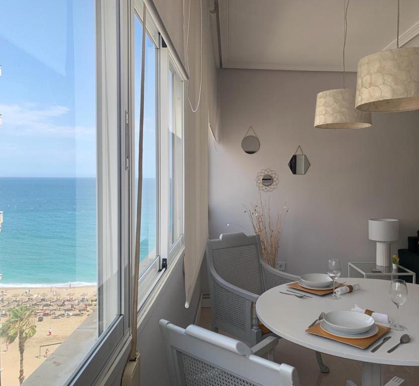 a dining room with a table and a view of the beach at SeaMed in Málaga