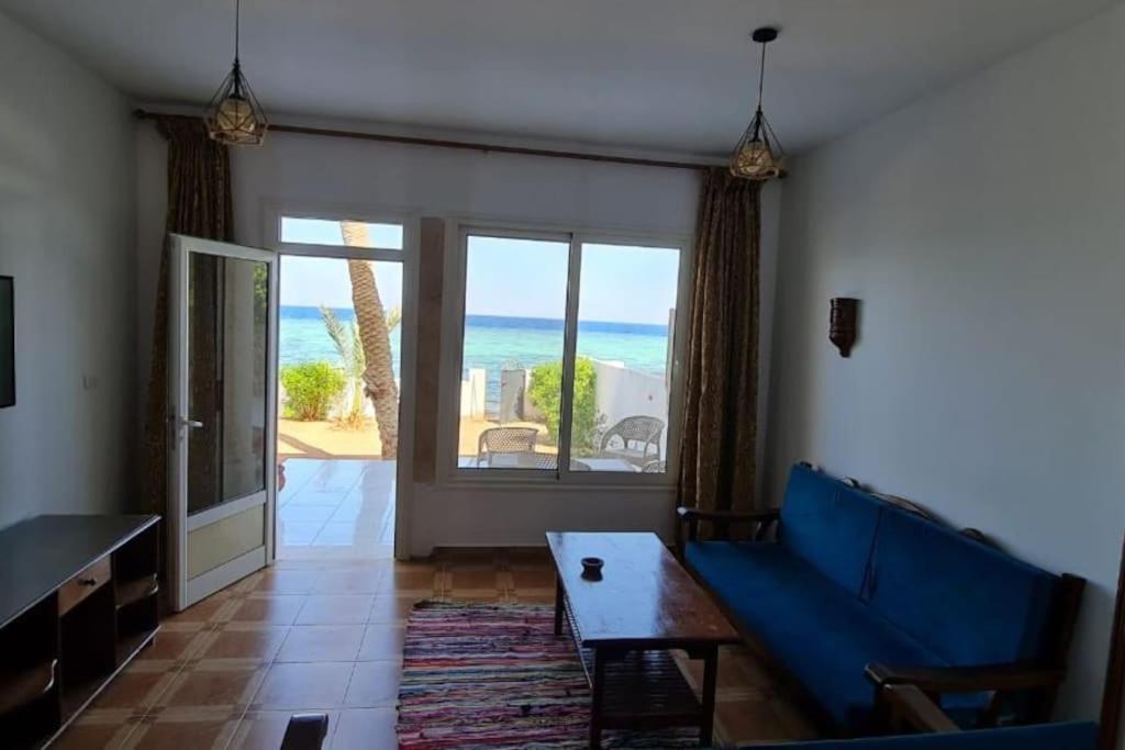 Sala de estar con sofá azul y vistas al océano en Sea Breeze Beach House, en Dahab