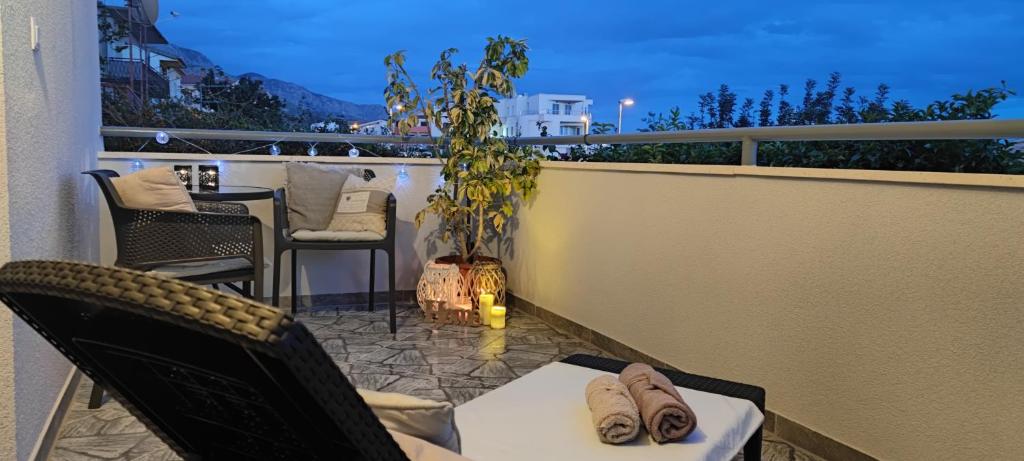 een balkon met stoelen en een tafel en een plant bij Rooms Lucky in Makarska