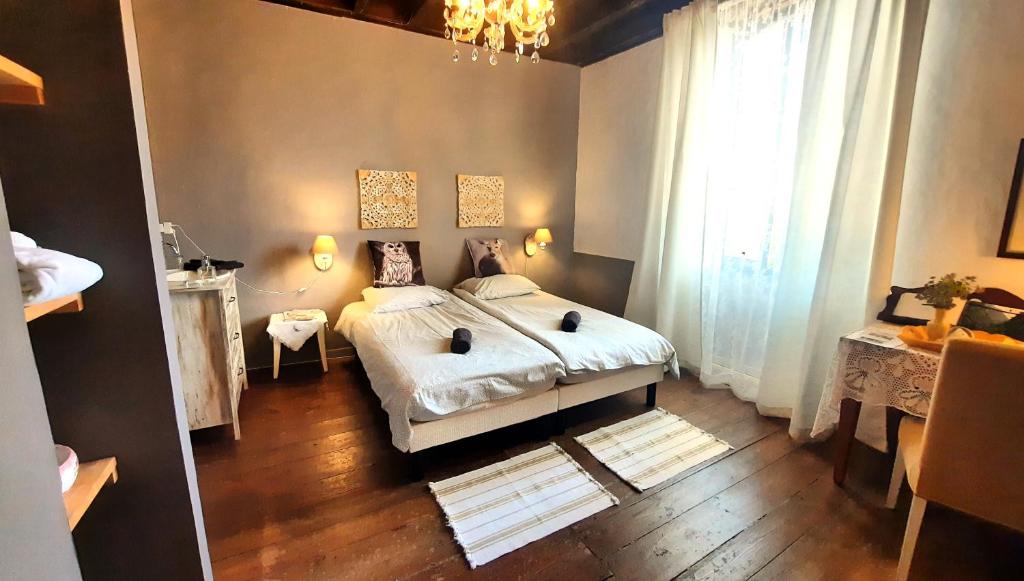 Un dormitorio con una cama grande y una lámpara de araña. en Chambre d'hôte, en Castex