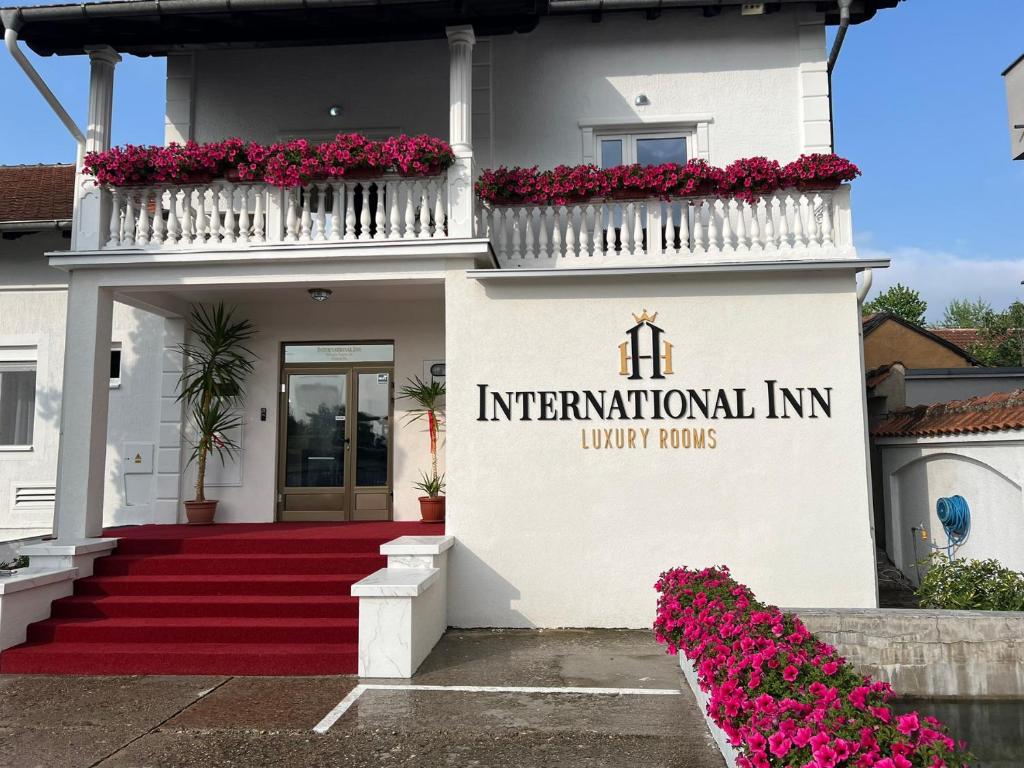 パラチンにあるInternational Innの赤い絨毯と花の白い建物
