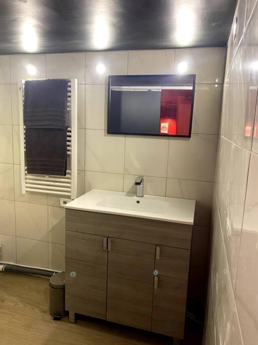 a bathroom with a sink and a mirror at Le CinéGlam Spa in Margny-lès-Compiègne