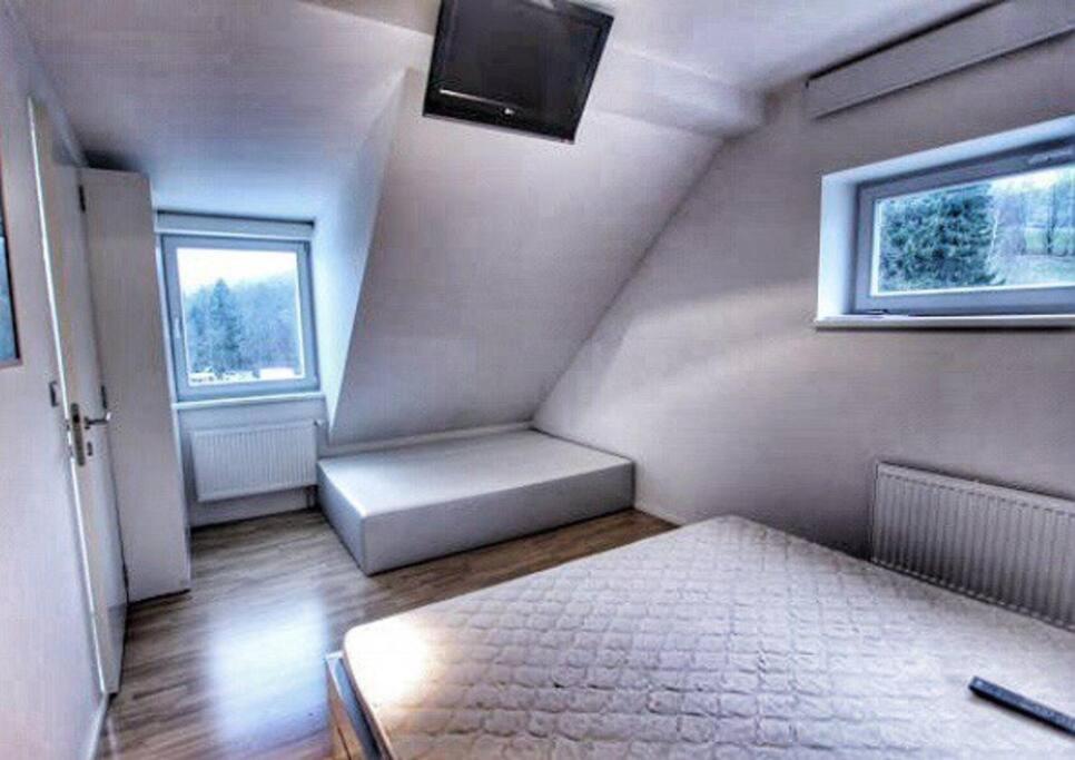 una piccola stanza con un letto e una finestra di Horský apartmán s výhledem na Lysou horu a Rokytnice nad Jizerou