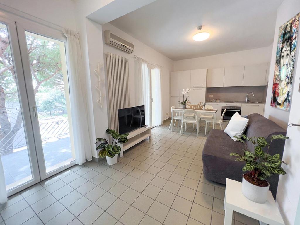a living room with a couch and a table and a kitchen at Residenza Clelia Riccione in Riccione