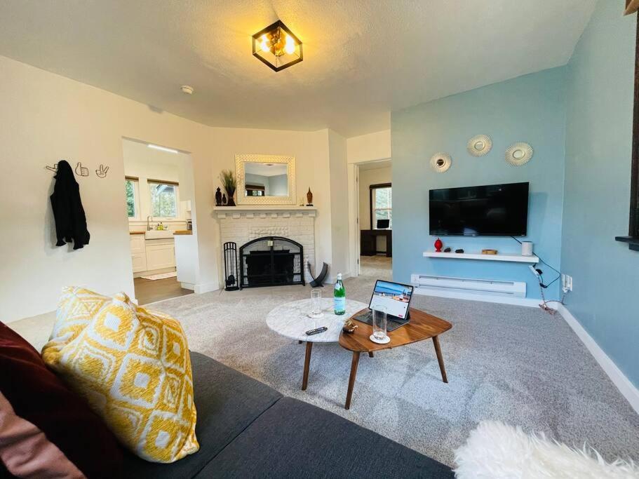a living room with a couch and a table with a laptop at Phinneywood Cottage - Greenlake - Zoo - Phinney in Seattle