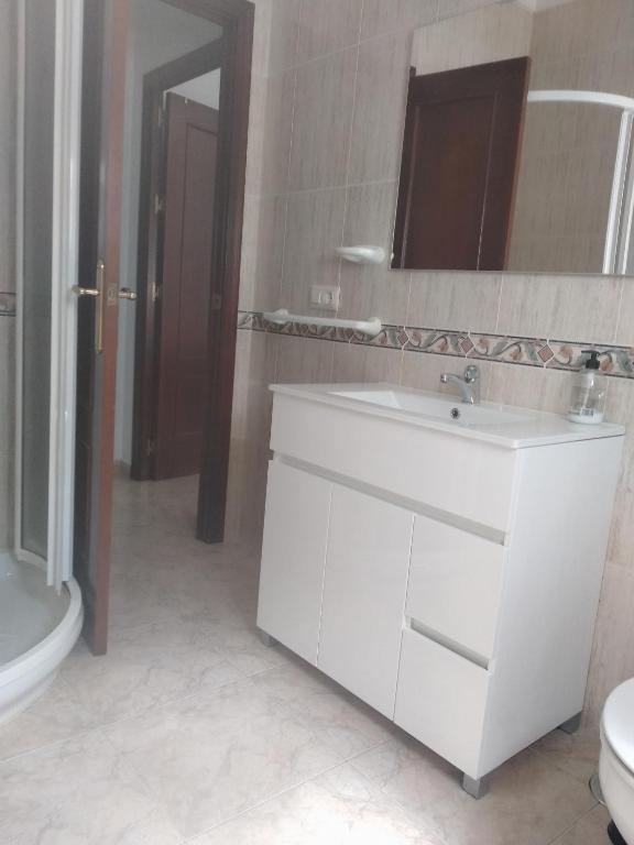 a bathroom with a sink and a toilet and a mirror at El 20 in Barbate