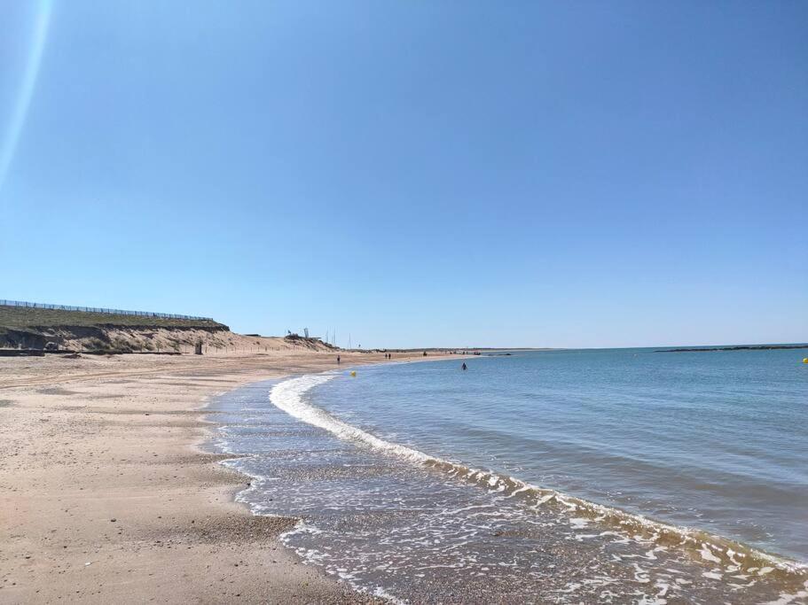 a beach with the ocean and the shoreline at Maison centre ville de Brétignolles sur Mer in Brétignolles-sur-Mer